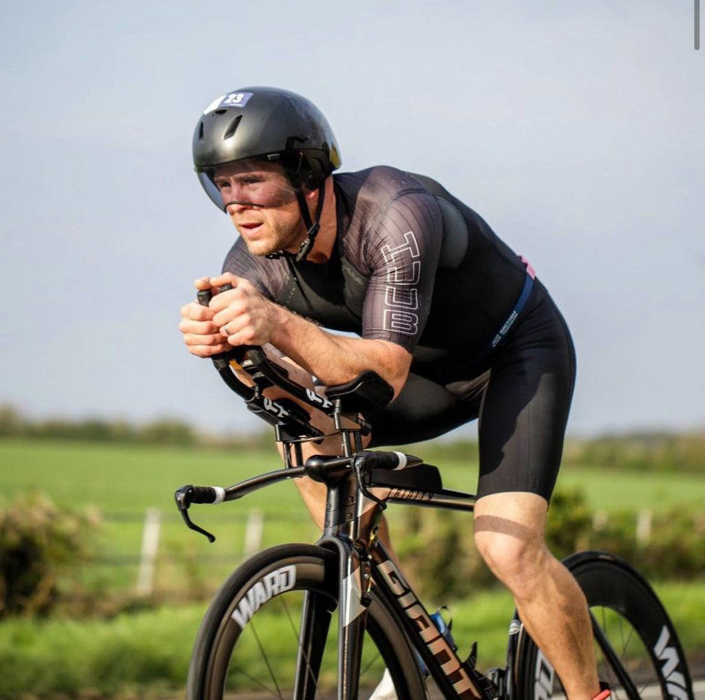 SF Planning Sponsors Local Triathlete. A photograph of a male trathlete, ben Bowers, riding his competition bike.